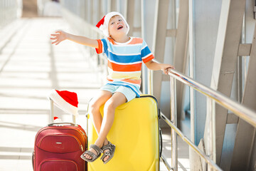 Wall Mural - Happy kid at the airport in christmas cap