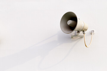 Old loud speaker on the white wall on ferry