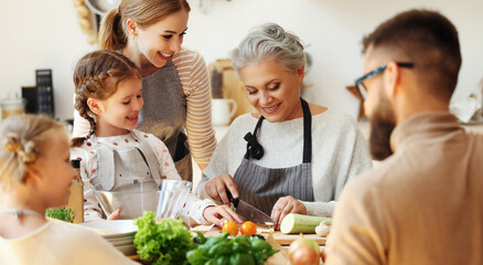 Wall Mural - Happy family preparing healthy food in home kitchen.