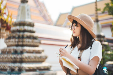 Wall Mural - Young adult traveller asian woman writing memo journal list.