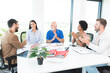 © focusandblur - Business team applauding and congratulating colleague at group meeting