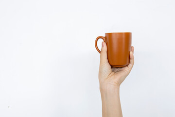 closeup hand holding cup of coffee in white background with soft-focus and over light in the background