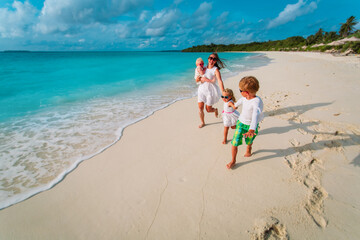 Wall Mural - mother with kids play, family run on tropical beach