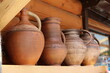 Rustic large earthenware wine jugs / pots. Set of vintage jugs on a shelf isolated on a wooden background. Handmade ceramic jugs and clay pots on the market.