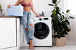 Cropped view of barefoot woman holding laundry basket near washing machine during housework at home