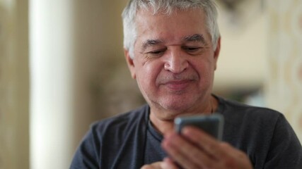 Casual elder man using cellphone device feeling satisfied
