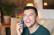 © ajr_images - Young hispanic using retro style landline cordless phone