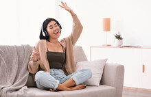 Asian Woman Listening To Music In Headset And Dancing