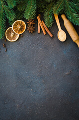 Wall Mural - Christmas culinary background for menu or recipe. Spices for baking and fir branches on concrete.