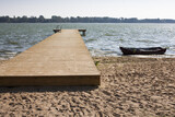 Fototapeta Pomosty - Plaża nad jeziorem z dużym drewnianym pomostem