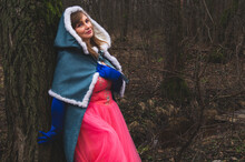 Woman With Mantle Leaned Against A Tree. Adult Woman In Fantasy Costume With Cape