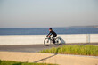 © Алексей Васильев - A woman rides a bicycle along the embankment. Riding a bicycle. Outdoor sports. Embankment of the Gulf of Finland Russia St. Petersburg.Cycling workout