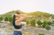 © janckerphoto - Young woman standing with her hair done before she started running. Healthy living, running in the mountains.