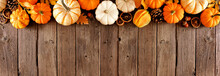Long Fall Border Of Pumpkins And Natural Autumn Decor. Top View On A Rustic Dark Wood Banner Background With Copy Space.