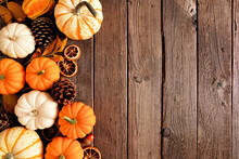 Autumn Side Border Of Pumpkins And Natural Fall Decor. Overhead View On A Rustic Dark Wood Background With Copy Space.