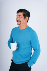 Wall Mural - Senior man in blue long sleeve shirt with white coffee cup.