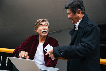 Wall Mural - Two senior engineers working outdoors with computer laptop.