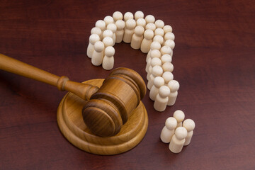 Legal questions and answers concept, social rights theme. Many people as question mark and wooden judge gavel.