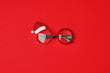 Google glasses Santa's Christmas on red background. Masquerade festive party new year funny sunglasses, trendy minimal winter holiday idea, banner, flyer, coupon