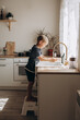 © Елена Лавринович - A boy of European appearance washes his hands in a light kitchen at home.