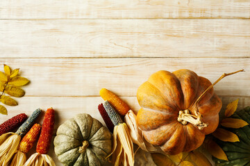 Wall Mural - thanksgiving and fall holidays background with pumpkins, corn and fall leaves. top view. copy space.