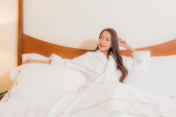 Wall Mural - Portrait beautiful young asian woman smile relax on bed in bedroom interior