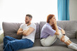 © alfa27 - caucasian depressed redhead wife feeling upset after fight with husband, sit back to back. frustrated young girlfriend and boyfriend avoiding talk, couple tired of bad relationships, sit on sofa