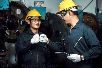 Wall Mural - team of Asian engineer mechanic man get handshake together after checking and repair pressing metal machine at factory, teamwork concept