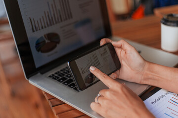 Wall Mural - business woman using smartphone to analyze financial data.