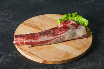 Raw beef bacon over wooden board