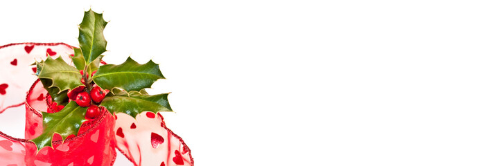 Wall Mural - Christmas panoramic web banner with a branch of holly and red ribbon isolated on white background