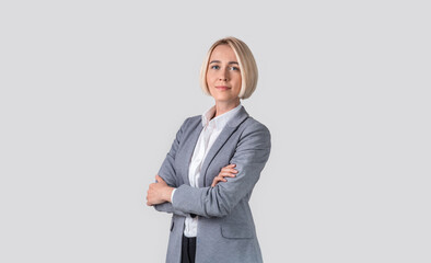 Portrait of serious confident business lady posing with crossed arms on light grey studio background, panorama