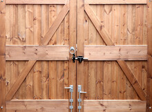 Double Wooden Gates In Closeup Rear View With Metal Fittings
