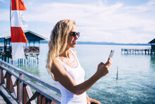 Shapely Female Standing At Pier And Taking Selfie