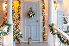 Christmas Porch Decoration Idea. House Entrance Decorated For Holidays. Golden And Green Wreath Garland Of Fir Tree Branches And Lights On Railing. Christmas Eve At Home.