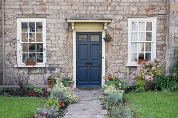 front door of old house with flowers in a garden