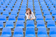 © michaelheim - Glum woman sitting in spectator seating