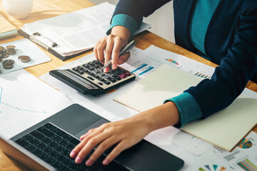 Fototapete - Woman accountant use calculator and computer with holding pen on desk in office. finance and accounting concept