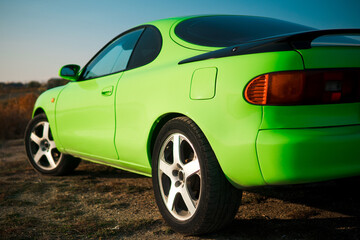 Green and black sport coupe car with big wheels. Japanese oldtimer.