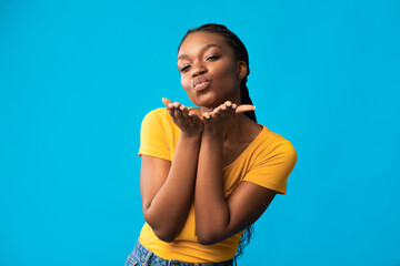 Pretty Black Lady Sending Air Kiss Flirting Over Blue Background