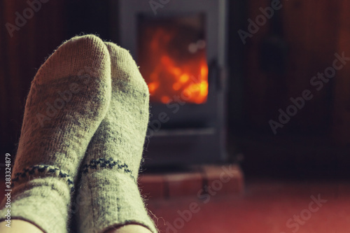 Cuadros en Lienzo Feet legs in winter clothes wool socks at fireplace background