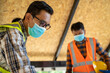 © visoot - Group of Worker man wearing hygienic mask and protective hard hat working at construction site,Safety concept.