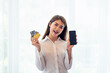 © surachetkhamsuk - Young Asian woman holding credit card and using mobile phone, Online shopping concept
