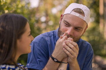 Guy kisses girl's hand. Looking at each other.