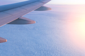 Wall Mural - passenger plane flying above the clouds. view from the wing of the plane. travel concept