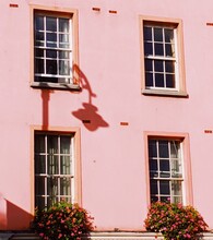 Pink House With Flowers On Balcony
