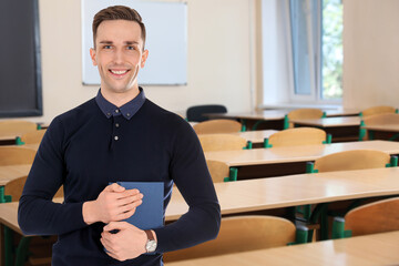 Wall Mural - Young teacher waiting for students in classroom