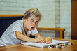 © NOVOZHILOV ANDREI - Portrait Preschool boy with open mouth enthusiastically draw holding pen notebook fun learn write, artistic facial expressions gestures. Children behaviour education problems, home school concept