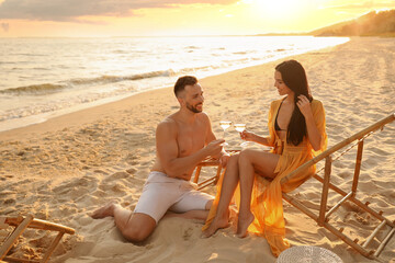 Sticker - Romantic couple drinking wine together on beach at sunset