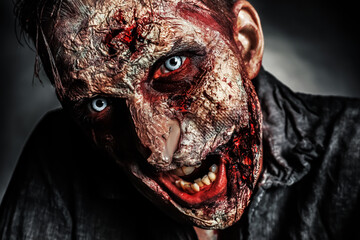 Scary zombie on dark background, closeup. Halloween monster